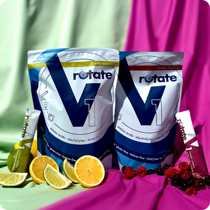 Rotate V1 Doppelpack: Forest Fruit und Lemon Lime Verpackungen nebeneinander mit je einem Stick, umgeben von Zitrusfrüchten und Beeren