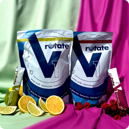 Rotate V1 Doppelpack: Forest Fruit und Lemon Lime Verpackungen nebeneinander mit je einem Stick, umgeben von Zitrusfrüchten und Beeren